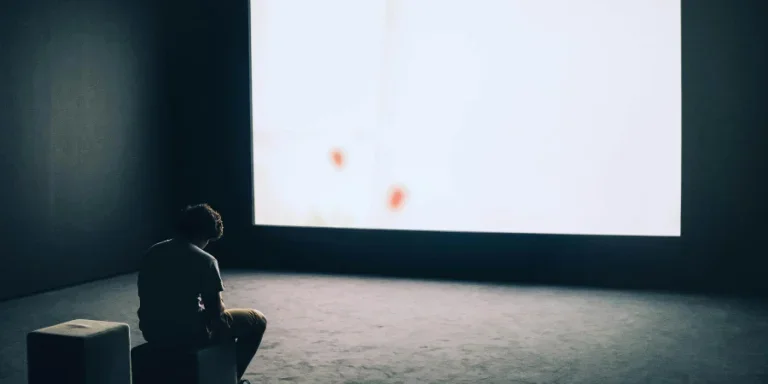 Man Sitting in Front of Turned-on Screen