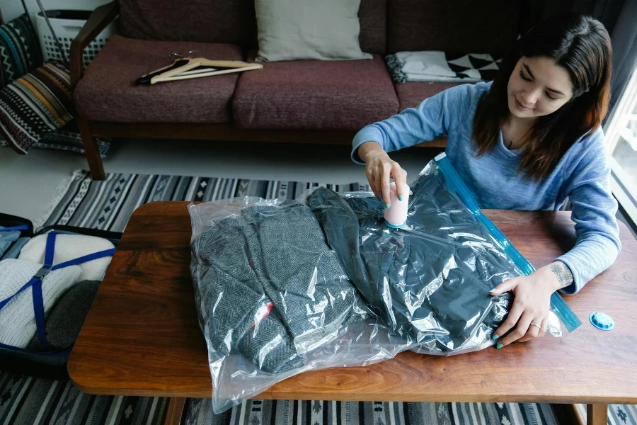 A Woman Vacuum Packing Clothes on a Table