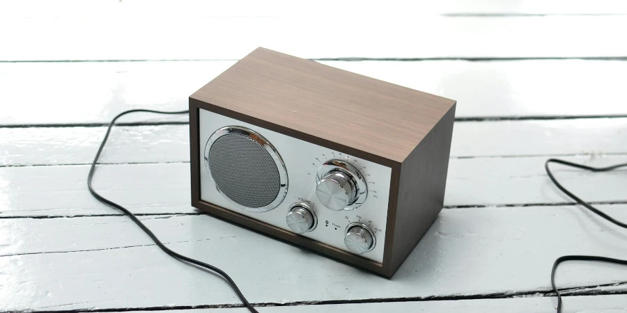 From above of vintage styled FM radio with wooden case and steel buttons placed on white lumber table