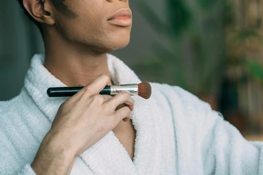 Anonymous black man with cosmetic brush