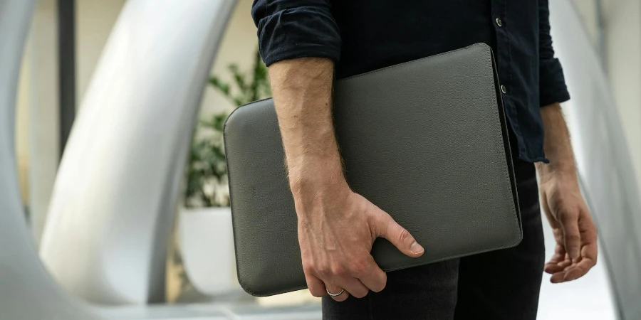 Close-up of a Man Holding a Leather Case with a Laptop