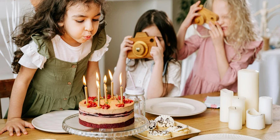 A Girl Blowing Lighted Candles on a Cake