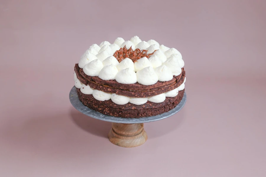 A Chocolate Layer Cake with Cream Standing on a Cake Stand