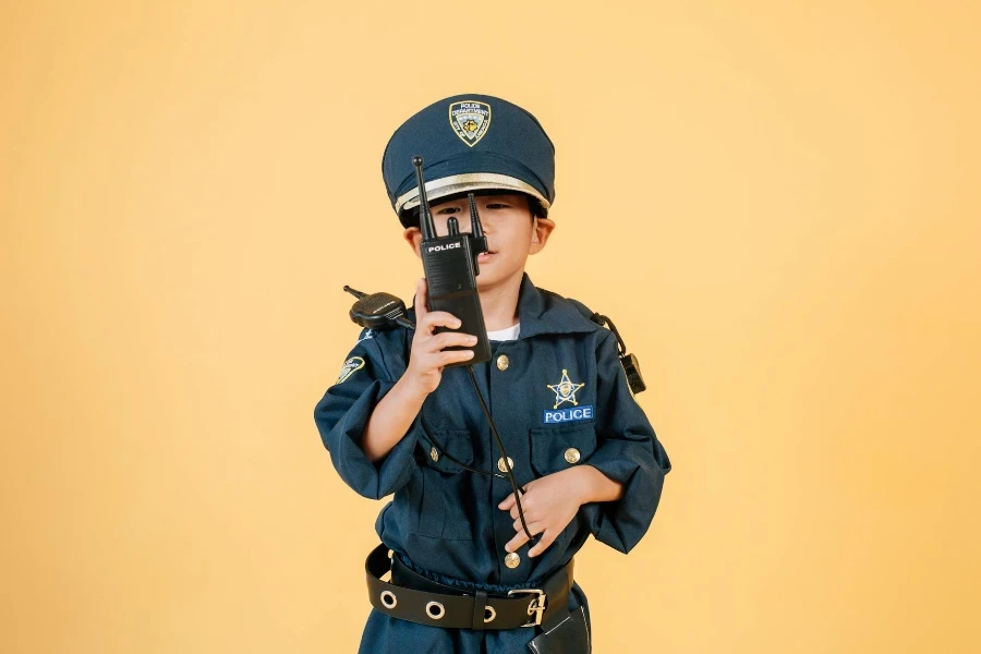 Asian boy in police uniform against yellow background