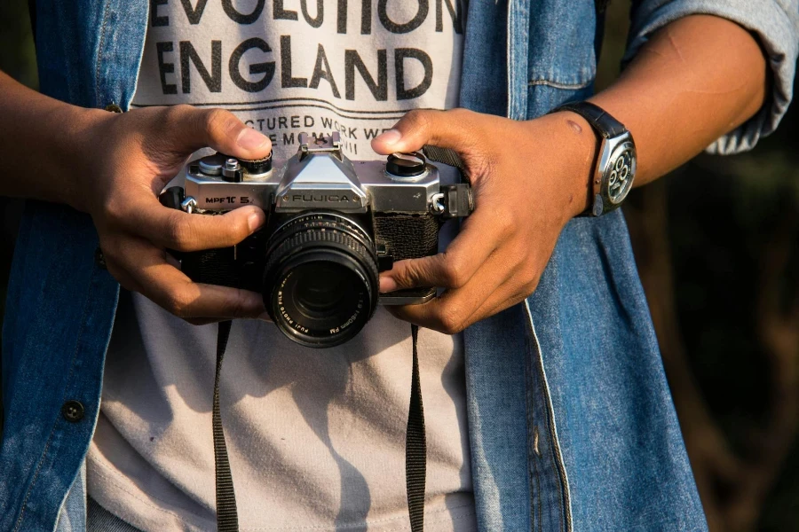 Person Holding Black SLR Camera