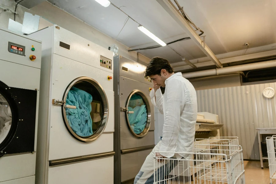 A Man Waiting of his Clothes while Washing Inside the Machine