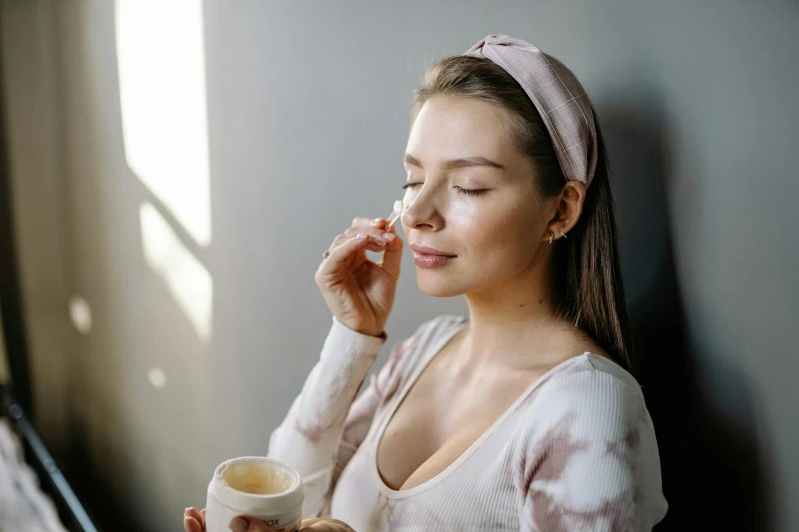 Photo of a Woman Applying Cream on Her eyes 