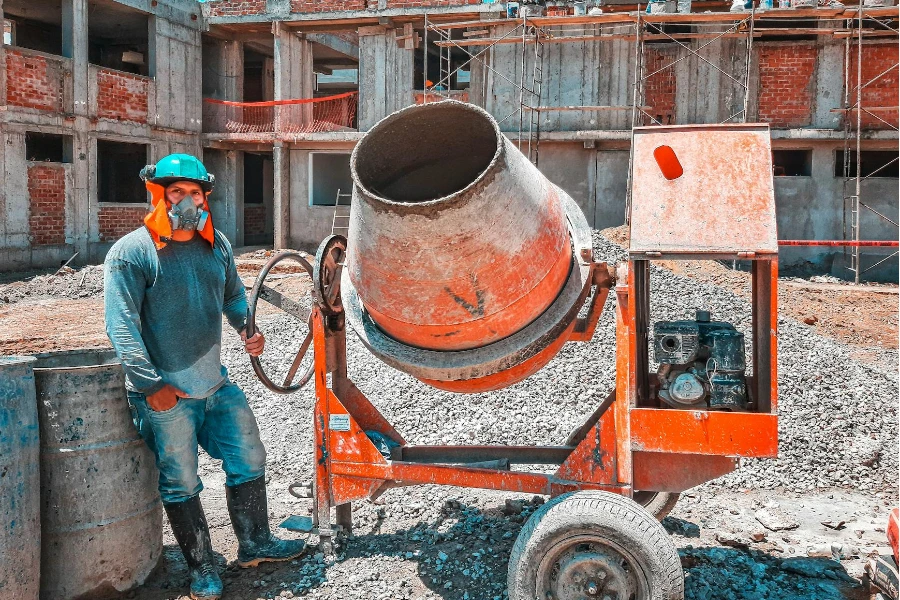 Worker with Gas Mask Operating Concrete Mixer