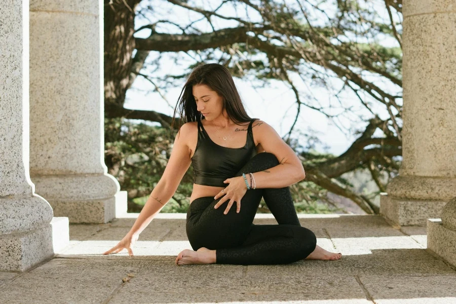 Woman in Black Tank Top and Black Leggings Sitting on Floor