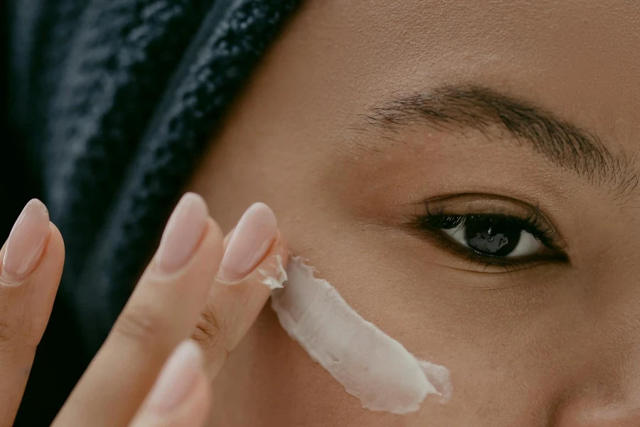 Woman applying eye Cream on Face 