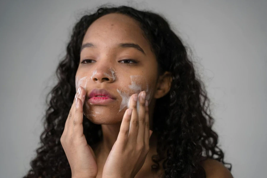 African American female with long dark curly hair washing cheeks