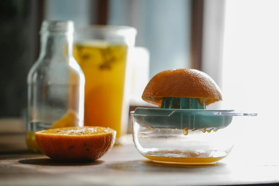 Half of delicious sweet orange placed on plastic orange juicer