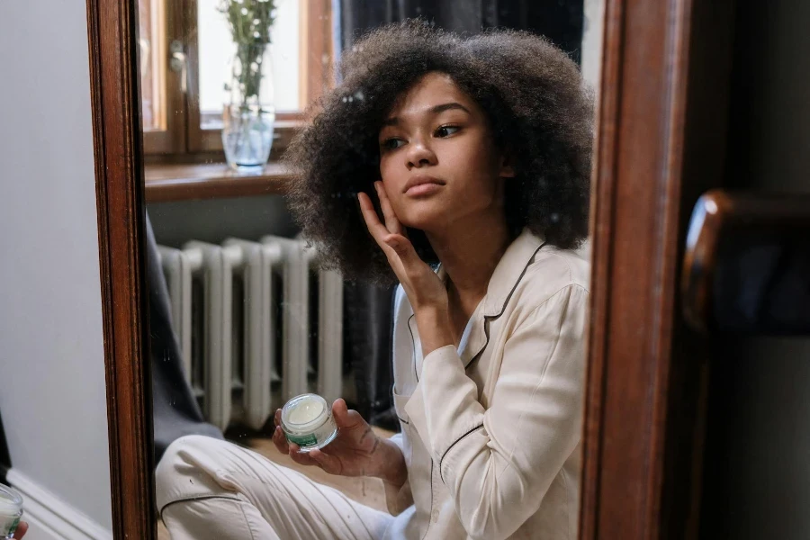 a woman is applying retinoid cream