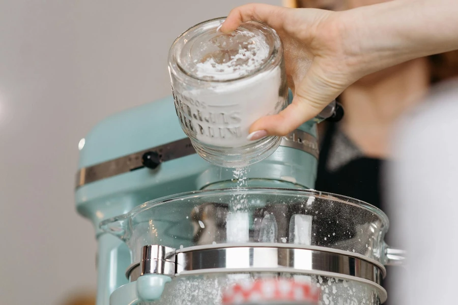 Person Pouring Flour on a Mixer