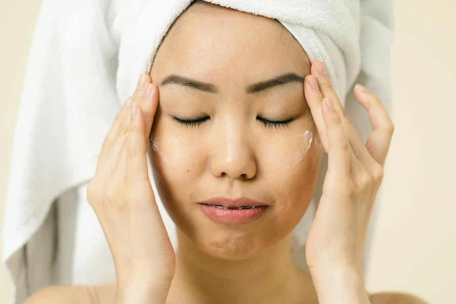 Woman putting cosmetic on her face