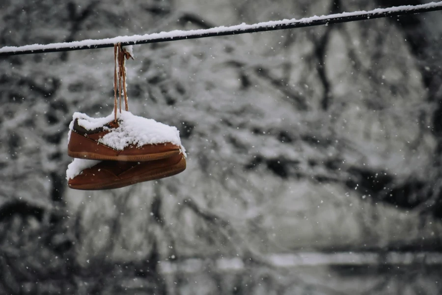 Old boots hanging on rope in winter day