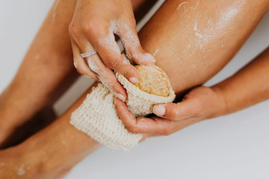 Person Using a Body Scrub on Legs