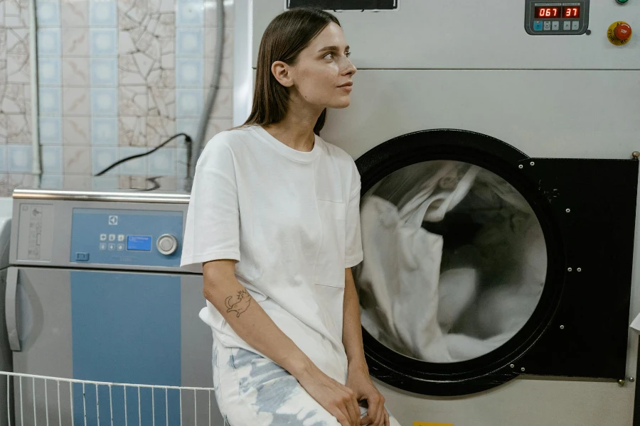 A Woman in White Shirt Leaning on the Machine
