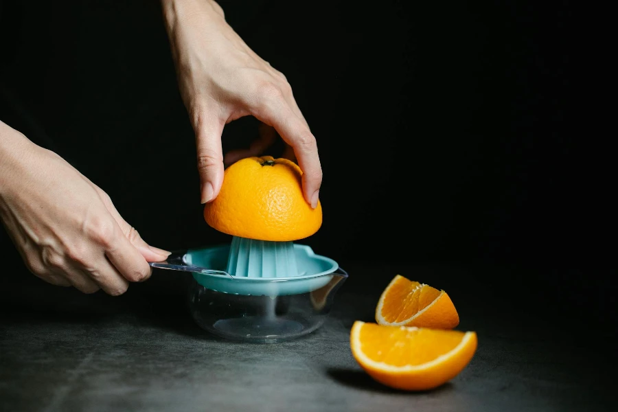 Close Up Photo of a Person Making Orange Juice