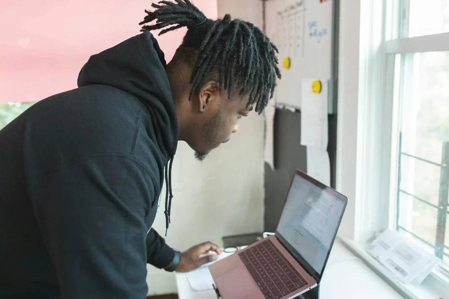 Man Standing in Front of the Laptop