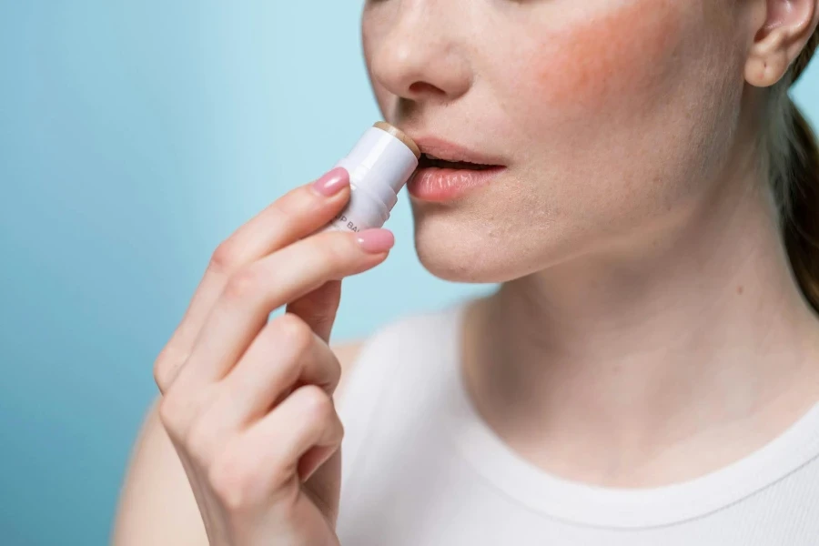 Crop Photo Of Woman Using A Lip Balm