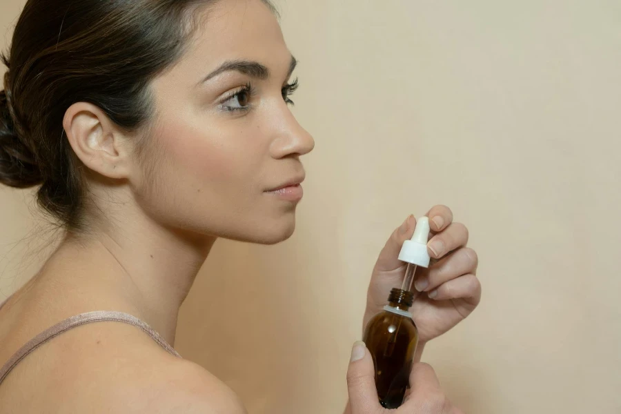 A Woman Holding a Bottle of Serum with Dropper