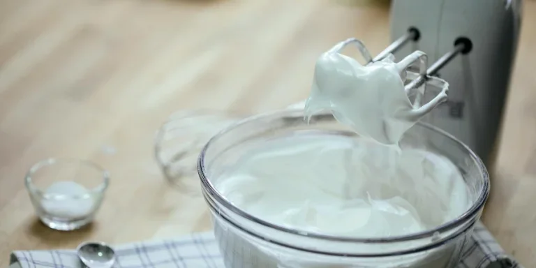 Composition on bowl with delicious whipped cream near mixer