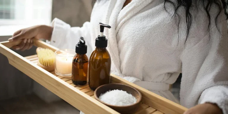 Unrecognizable African American female in white bathrobe with bottles of cosmetic