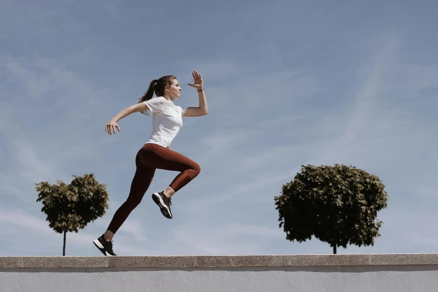 Woman in White Shirt and Leggings Running