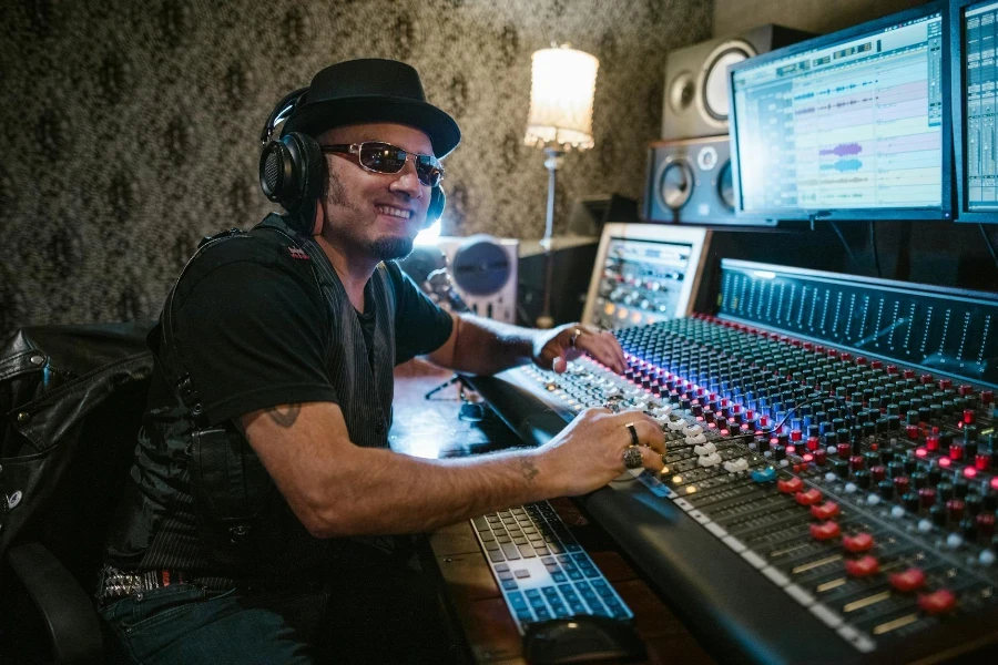 A Man in Black Shirt Playing Audio Mixer