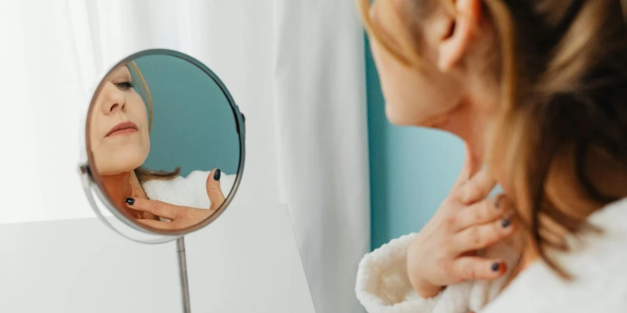 Woman Applying Cream to her Neck in Mirror