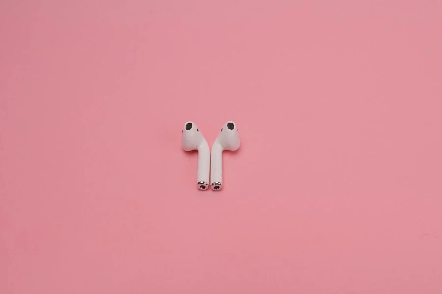 White Wireless Earphones on Pink Surface