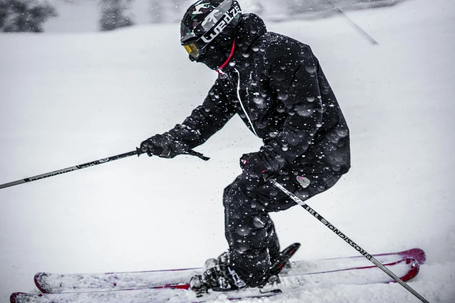 A Person in Black Ski Suit Skiing in Snow