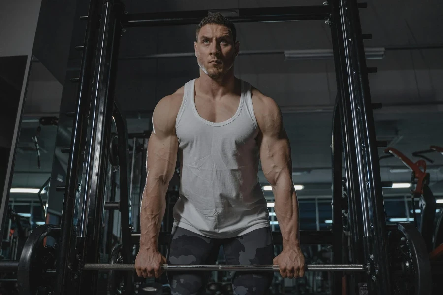 Man in White Tank Top Lifting Weights