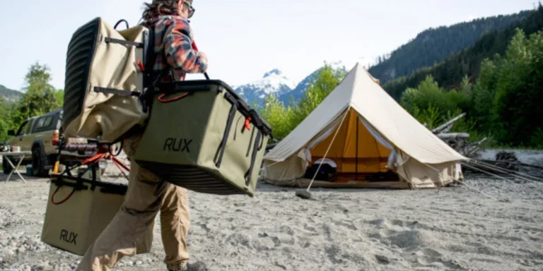 Person hauling multiple storage boxes to a campsite