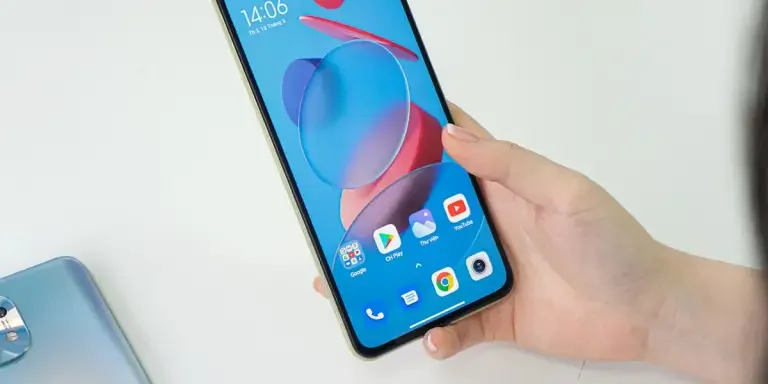 Person holding a smartphone displaying colorful screen with app icons