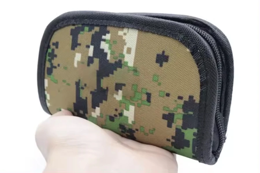 Person holding camouflage fishing wallet with black zipper