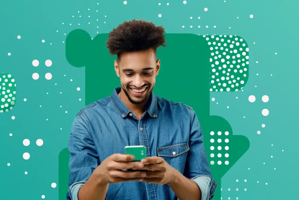 smiling man in blue shirt looking at his phone