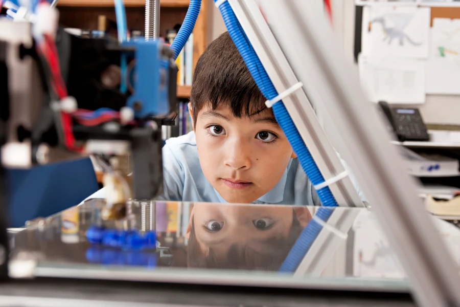 Student watching a 3D printer printing