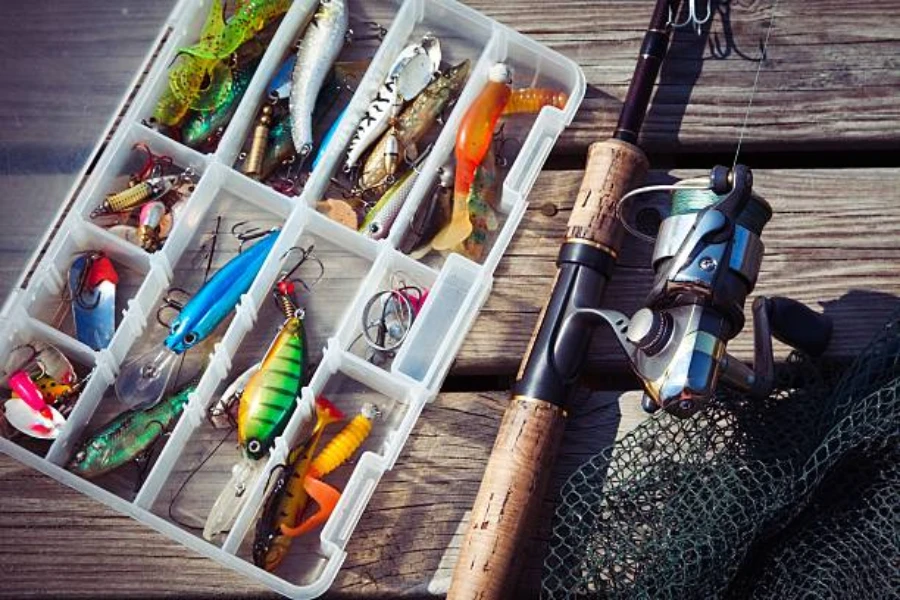 Tacklebox filled with fishing lures next to fishing rod