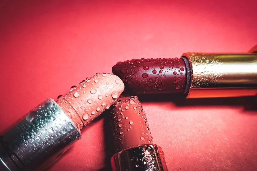 Three lipsticks joined together on a red background