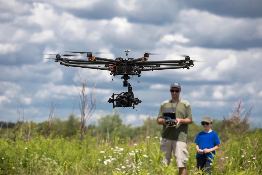 Two people flying a drone in a field