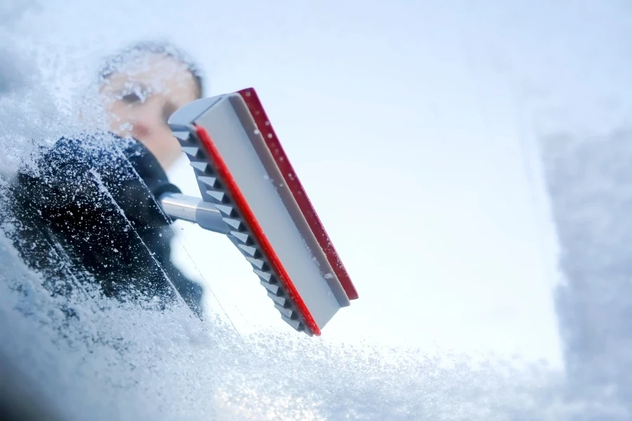 Woman scraping ice from a windshield