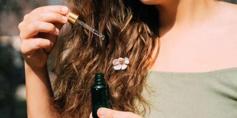 Woman applying serum on her hair