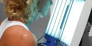 Mujer disfrutando de una sesión de bronceado con una máquina de bronceado facial