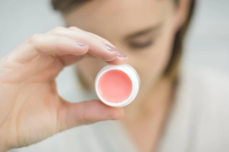 Woman holding a container of lip balm