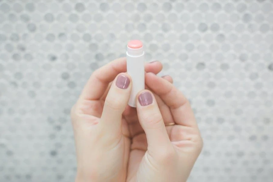 Woman holding a stick of lip gloss