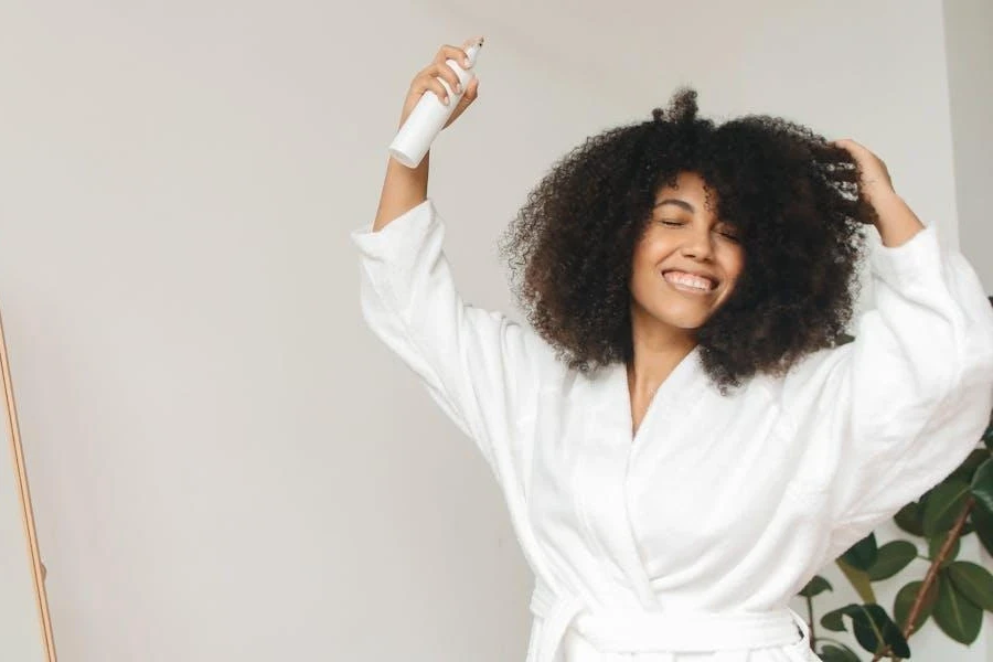 Woman using a spray on her full, curly hair