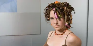 An attractive girl with curlers in her hair sitting
