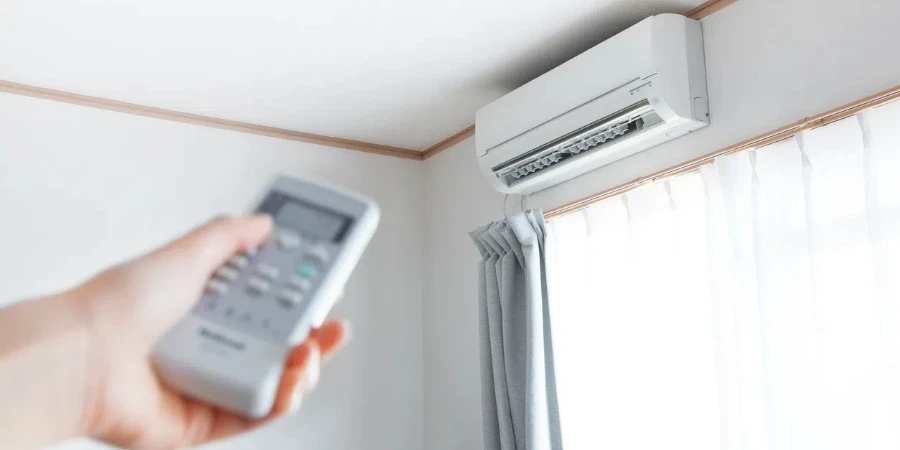 Hand with remote control directed on the conditioner